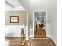 Hallway view of a hardwood floor and area rug leading to a formal living room with a fireplace at 3805 Watermark Dr, Franklinton, NC 27525