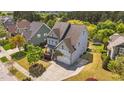 A bird's eye view of a light blue house with a manicured lawn and a driveway leading to a two-car garage at 3832 Crimson Clover Ave, Wake Forest, NC 27587