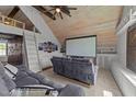 Attic bonus room featuring a movie screen, custom built-ins, wooden ceiling and a gray sofa at 3832 Crimson Clover Ave, Wake Forest, NC 27587