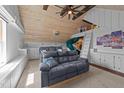 Bright bonus room with a slide, custom built-ins, wooden ceiling, and comfortable gray sofas at 3832 Crimson Clover Ave, Wake Forest, NC 27587
