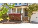 Inviting front entrance with stone steps, columns, and a colorful garden at 3832 Crimson Clover Ave, Wake Forest, NC 27587