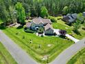Expansive aerial view of a brick home with a large yard, mature trees, and basketball court at 4001 Belmont Forest Way, Raleigh, NC 27606