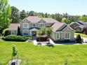 Beautifully landscaped brick home with a well-maintained lawn and mature trees at 4001 Belmont Forest Way, Raleigh, NC 27606