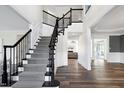 Elegant foyer with a staircase featuring a black wrought iron railing and gray carpet steps at 4001 Belmont Forest Way, Raleigh, NC 27606