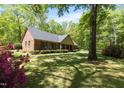 Beautiful brick house with blooming azaleas and mature trees creating a serene setting at 4298 Old Stage S Rd, Erwin, NC 28339