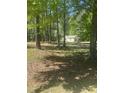 Exterior of the home with a covered front porch nestled amongst the trees at 4501 Duraleigh Rd, Raleigh, NC 27612