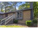 Brick house featuring a welcoming staircase to the front door and lush, green landscaping at 500 W Woodcroft Pkwy # 13D, Durham, NC 27713