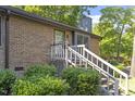 Lovely brick home showing the walkway to the front door, framed by green bushes and trees at 500 W Woodcroft Pkwy # 13D, Durham, NC 27713