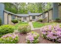 Inviting townhome featuring fresh landscaping, colorful flowers, and a charming brick exterior at 500 W Woodcroft Pkwy # 17C, Durham, NC 27713
