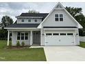 Inviting two-story home boasts gray siding, a two-car garage, and a meticulously maintained front lawn at 520 S Lincoln St, Benson, NC 27504