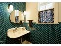 Stylish bathroom featuring a unique sink, elegant fixtures, and vibrant turquoise herringbone tile at 5265 Aleppo Ln, Raleigh, NC 27613