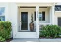 Elegant front entrance featuring a black door, white trim, and decorative shrubs for curb appeal at 5265 Aleppo Ln, Raleigh, NC 27613