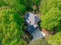 Aerial view of a house nestled amongst lush green trees, providing privacy at 5504 Spring Bluffs Ln, Raleigh, NC 27606