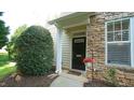 Charming front entrance featuring a black door, stone facade, and manicured landscaping at 5901 Chivalry Ct, Raleigh, NC 27612