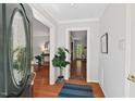 Bright foyer with hardwood floors and an elegant oval glass window on the front door at 6614 Chantilley Place, Bahama, NC 27503