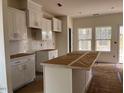 Kitchen with stainless appliances, white cabinets, island, and a tile backsplash at 1003 Shovelhead Dr # 2, Durham, NC 27703