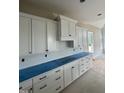 The kitchen has white cabinets, drawers, and a blue countertop cover at 1021 Azalea Garden Cir, Raleigh, NC 27603