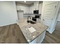 Bright kitchen featuring granite countertops, stainless appliances, and hardwood flooring at 10527 Brookside Reserve Rd, Raleigh, NC 27614