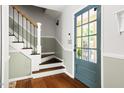 Welcoming entryway featuring hardwood floors, stairs, and a glass-paneled front door at 109 Bessemer Pl, Durham, NC 27712