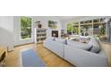 Bright living room with a fireplace, built-in shelving, and large windows overlooking the backyard at 1101 Norris St, Raleigh, NC 27604