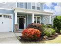 Inviting front entrance with colorful landscaping, black front door, and craftsman columns under a covered porch at 1209 Redwood Valley Ln, Knightdale, NC 27545