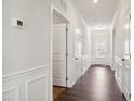 Bright hallway with hardwood flooring, white trim, and multiple entryways to rooms at 1316 London Meadow Way, Fuquay Varina, NC 27526