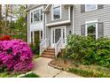 Close up of a home's entry with brick steps and colorful flowering bushes at 1412 Amberton Ct, Raleigh, NC 27615