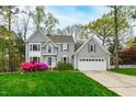 Charming two-story home with gray siding, attached garage, and a well-manicured lawn at 1412 Amberton Ct, Raleigh, NC 27615