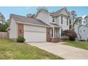 Two-story home with gray siding, brick accents, attached garage and manicured front lawn at 145 Richmond Park Dr, Cameron, NC 28326