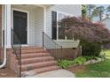 Front porch of the home with brick steps, black front door, and a charming Japanese maple tree at 145 Richmond Park Dr, Cameron, NC 28326