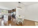 Dining area with hardwood floors and an island with granite countertops at 2027 Hayes Ln, Holly Springs, NC 27540