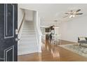 Bright entryway showcasing hardwood floors and staircase leading to upper level, with open layout to the dining at 2027 Hayes Ln, Holly Springs, NC 27540
