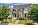 Charming brick townhome with well-manicured lawn and lovely seating area for relaxing outdoors at 2027 Hayes Ln, Holly Springs, NC 27540