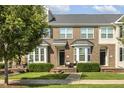 Charming brick townhome featuring manicured landscaping and a welcoming front porch at 2027 Hayes Ln, Holly Springs, NC 27540