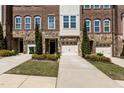 Charming townhome exterior with stone accents, a small yard, and an attached one-car garage at 212 Allister Dr, Raleigh, NC 27609