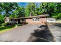 Well-kept brick home with a long driveway and a detached garage, surrounded by lush greenery at 2307 Piedmont Dr, Sanford, NC 27330