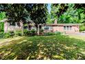 All brick single-story home with inviting front porch, an American flag, and landscaped front yard at 2307 Piedmont Dr, Sanford, NC 27330