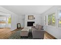 Bright living room features refinished fireplace, hardwood floors, and natural light from windows at 2605 Joe Pruitt Rd, Oxford, NC 27565