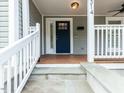 Charming home entrance with blue door, white trim, stone steps and wood porch provides curb appeal at 314 Gray Ave, Durham, NC 27701