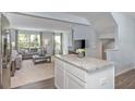 Open-concept living area with a stylish couch, large windows, and a convenient kitchen island at 338 Apricot Sun Way # 1196D, Zebulon, NC 27597