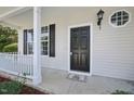 Covered porch and entryway featuring a black front door, white trim and accents, and a small porch mat at 3604 Rivermist Dr, Raleigh, NC 27610