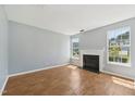 Bright living room boasts hardwood floors, fresh paint, modern fireplace, and large windows for natural light at 3604 Rivermist Dr, Raleigh, NC 27610