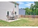 Lush backyard featuring a patio set with an umbrella and a swing set, perfect for outdoor enjoyment at 390 Hunting Wood Dr, Angier, NC 27501