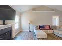 Living room showcasing fireplace, mantel, hardwood floors, and large windows at 395 Carolina Landing Dr, Zebulon, NC 27597