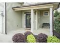 Inviting front porch with decorative columns and bench seating, framed by colorful landscaping at 45 Davelyn Ct, Garner, NC 27529