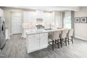 Bright kitchen featuring an island with bar seating, white cabinets, and stainless steel appliances at 533 Freedom Trail Dr, Willow Springs, NC 27592