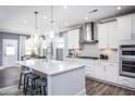 Modern kitchen boasts white cabinets, a large center island with seating, and stainless steel appliances at 755 Bachelor Gulch Way, Apex, NC 27523