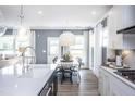 Open concept dining area features a modern light fixture and views of the backyard at 756 Bachelor Gulch Way, Apex, NC 27523