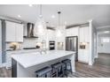 Elegant kitchen featuring quartz island, pendant lighting, stainless appliances, and white cabinetry at 760 Bachelor Gulch Way, Apex, NC 27523