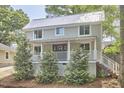 Charming two-story home with a metal roof, inviting front porch, and well-manicured landscaping at 918 Orient St, Durham, NC 27701